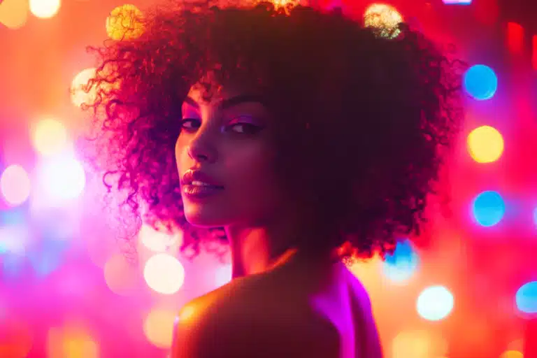 A sultry woman with kinky hair illuminated by colorful disco lights