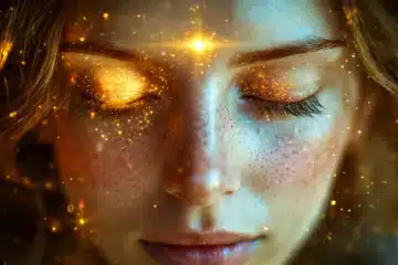 A woman's third eye is glowing with light and sparkles