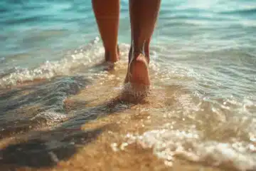 A woman walking into waves on the beach