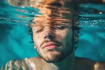 A man eyes closed meditating underwater